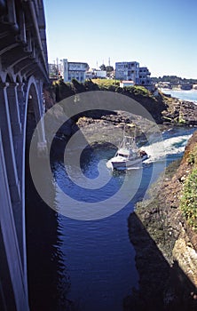 Boat enters Depoe Bay harbor which is one of the smallest harbors in the world