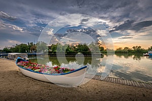 Boat filled with flowers in an iconic beautiful sunset landscape over the Danube Delta in Gura Portitei, Romania