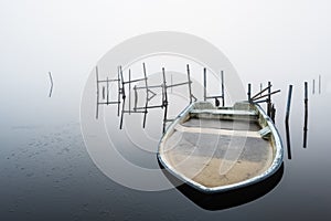 Boat filled with ice in a misty lake