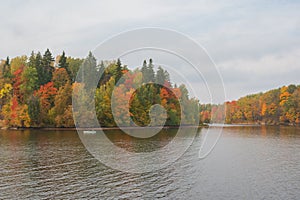 Boat with fishermen fishing in the Perse river in Koknese in colorful autumn