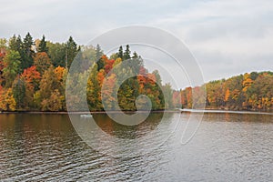 Boat with fishermen fishing in the Perse river in Koknese in colorful autumn