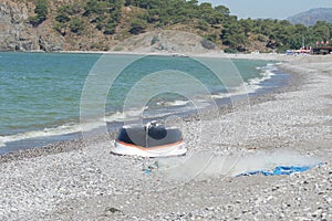 Fishing boat and net lie on the beach, Calis, Fethiye, Turkey.