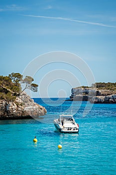 Boat floating on blue sea in Cala Mondrago bay at Mallorca, Spain