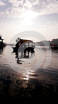 Boat floating on the river when sun rising with suprising clowds
