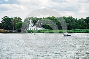 The boat floats on the Don River against the background of the old building of the Pilots` Station