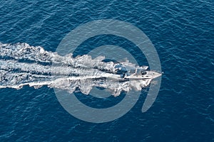The boat floats at high speed on the blue expanse of sea water, top view