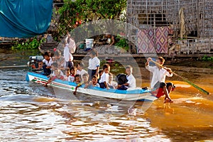 Students on a full boat return home after school, Cambodia