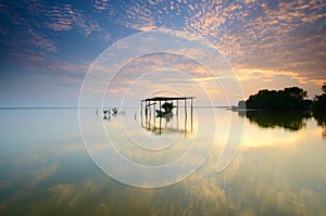 Boat on the garage at beautiful sunrise time.  Jubakar beach kelantan,  malaysia. Soft focus due to long exposure.