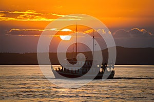 Boat glides under sunsets golden glow on Lake Baikal