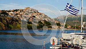 Boat in the harbor with castle on the hill at Molyvos Greece