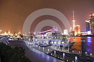 Boat at harbour behind is shanghai skyline at night