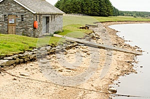 Boat House and Jetty Next to Beach and Lake