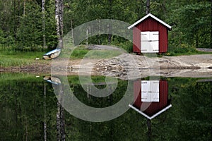 Boat house reflecting on lake