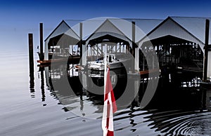 Boat houses are reflected in waters of Alberni Inlet photo