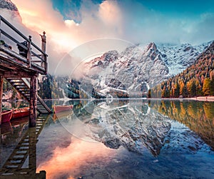 Boat hut on Braies Lake with Seekofel mount on background. Colorful autumn sunrise of Italian Alps, Naturpark Fanes-Sennes-Prags,