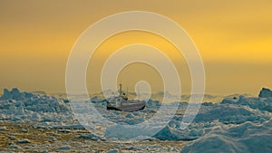 Boat in between Icebergs in Greenland. photo