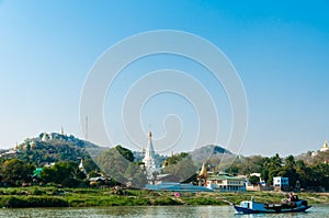 Boat on Irrawaddy river with Pagoda and village