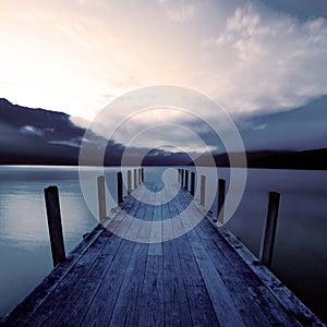 Boat jetty and a calm lake at sunrise, New Zealand.