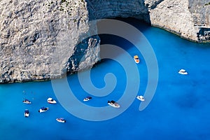 A boat in the lagoon near Navagio Beach, Zakynthos Island, Greece. View of the sea bay and a lone boat from a drone. Blue sea wate