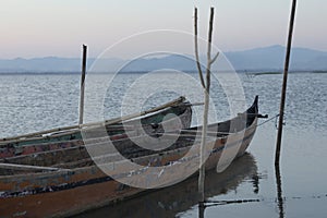 Boat in the lake at sunset. Rowing boat floating over the Limboto Lake waters. Gorontalo, Indonesia