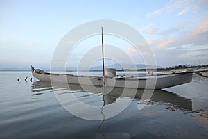 Boat in the lake at sunset. Rowing boat floating over the Limboto Lake waters. Gorontalo, Indonesia