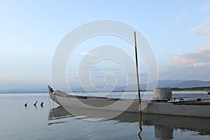 Boat in the lake at sunset. Rowing boat floating over the Limboto Lake waters. Gorontalo, Indonesia