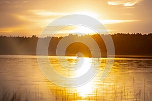 Boat on a lake surrounded by forest during sunset