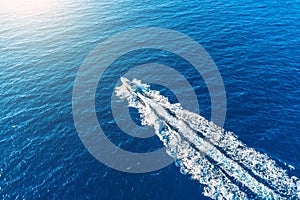 Boat launch at high speed floats to sunlight in the Mediterranean, aerial top view