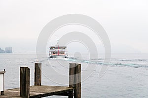 Boat leaving pier at Lucerne or Luzern lake Switzerland with heavy fog