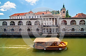 Boat on Ljubljanica river and St. Nicholas church in the background, Ljubljana, Slovenia