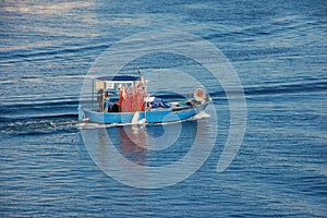 Boat of a lone fisherman in navigation for work a photo