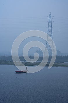 A boat man crossing river during rainfall