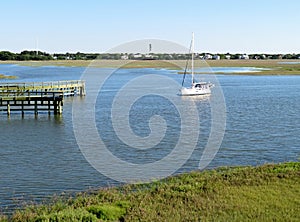 Sailboat floating on the marsh and wetlands along Shem Creek in Charleston, South Carolina photo
