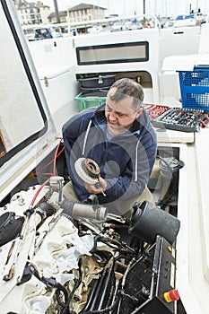 Boat mechanic repairing a ship engine