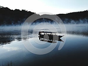 Boat in the middle of the misty lake