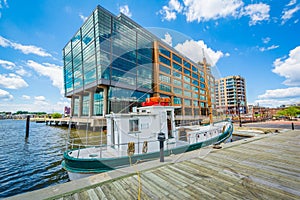 Boat and modern building along the waterfront in Fells Point, Baltimore, Maryland