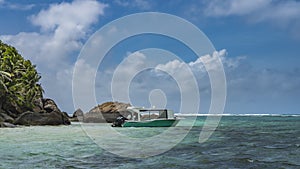 The boat is moored off the coast of a tropical island