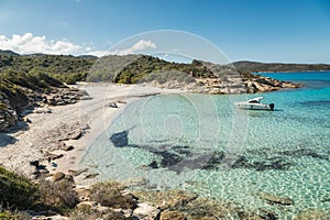 Boat moored in a small cove with sandy beach in Corsica