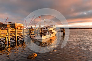 Boat moored to a jetty at sunset