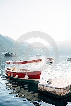Boat is moored to the pier overlooking the small islands in the Bay of Kotor
