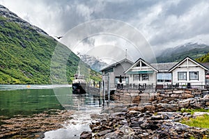 Boat moored to a pier in a small village in fjord. Norwegian landscape