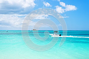 Boat with motor cruising on turquoise sea surface