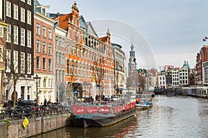 Boat, Munttoren Clock Tower and flower market in Amsterdam canal in Holland