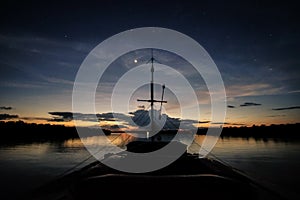 A boat navigates the Javari River after the sunset