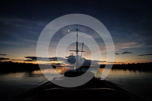 A boat navigates the Javari River after the sunset photo