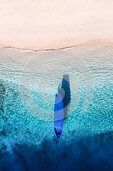 Boat near the beach. Seascape from drone. Blue water background from top view. Gili Meno island, Indonesia.