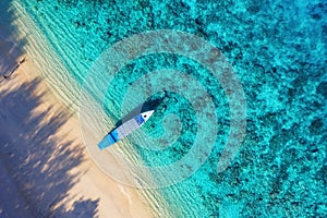 Boat near beach from top view. Turquoise water background from top view. Summer seascape from air. Gili Meno island, Indonesia.