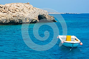 Boat near the rocky beach, view from the sea. Cyprus.