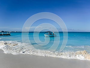 boat next to pier in beautiful beach with turquoise water in Grace Bay, Providenciales, Turks and Caicos