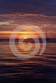 Boat on the ocean at sunset. Sailboats with sails. Sea yacht sailing along water.